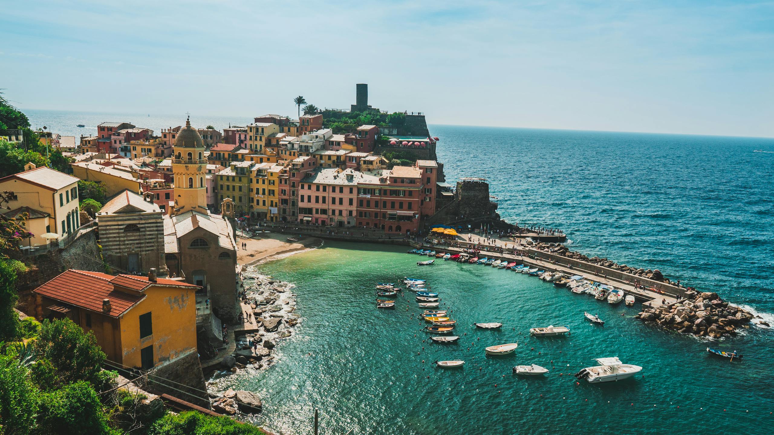 A picturesque aerial view of Vernazza's colorful buildings and harbor along the Italian coastline.