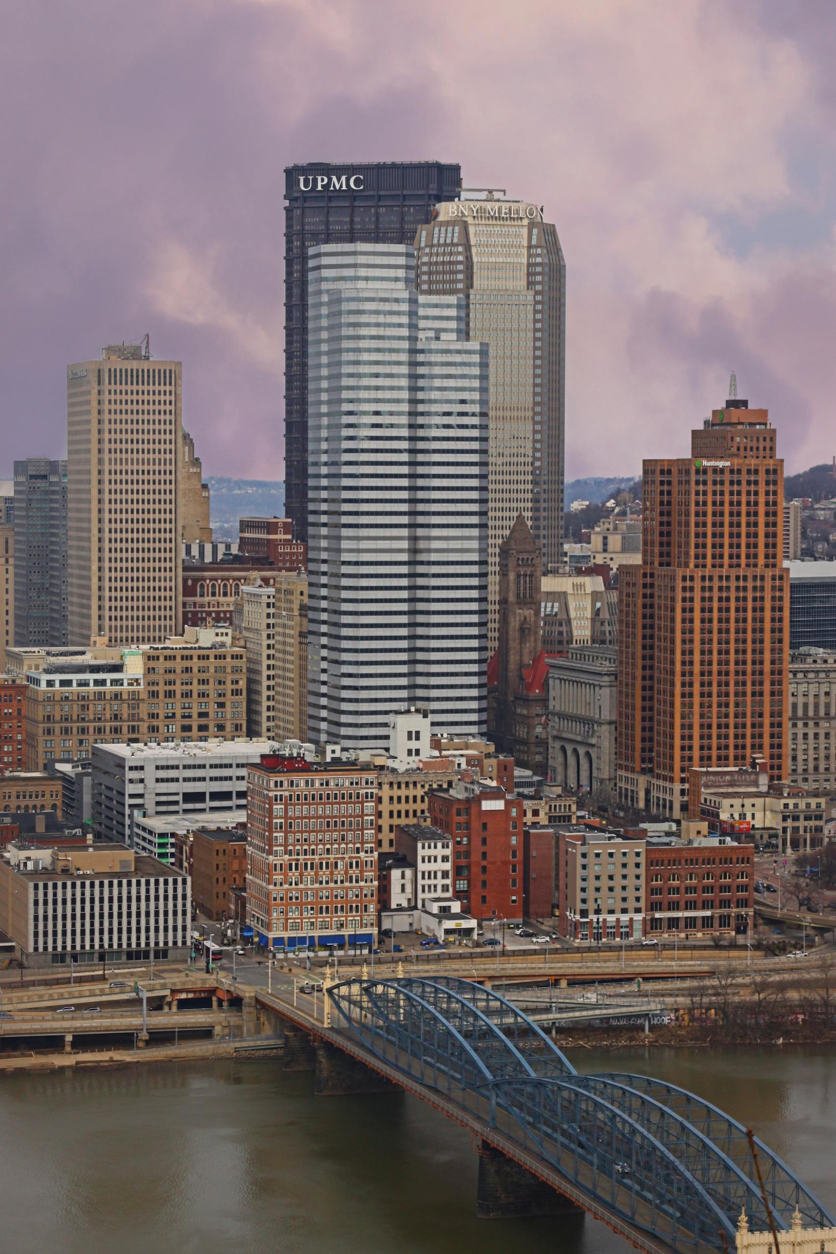 A vibrant aerial view of downtown Pittsburgh highlighting its iconic skyscrapers and river bridge.