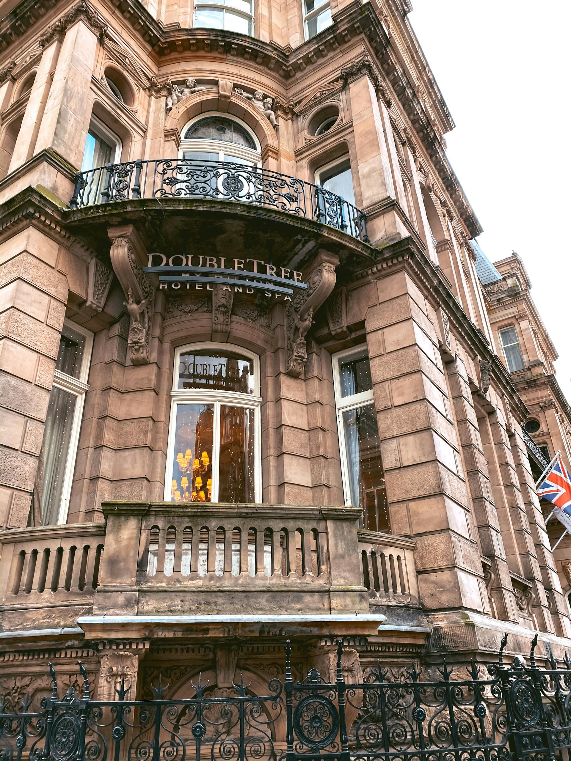 Elegant facade of a historic DoubleTree Hotel in London, showcasing classic architecture with wrought iron details.