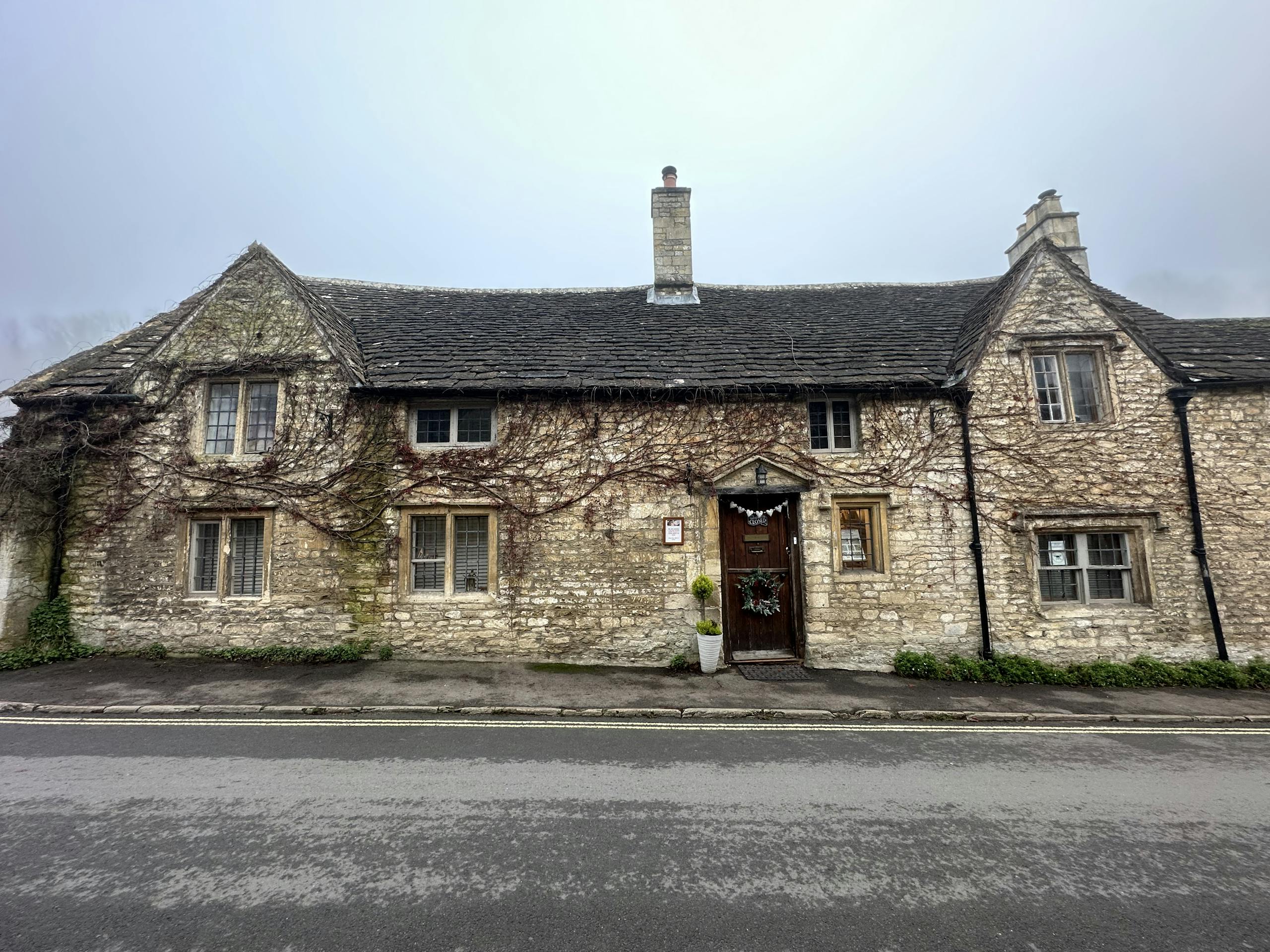 Quaint stone house with ivy in Castle Combe, England, showcasing historic architecture.