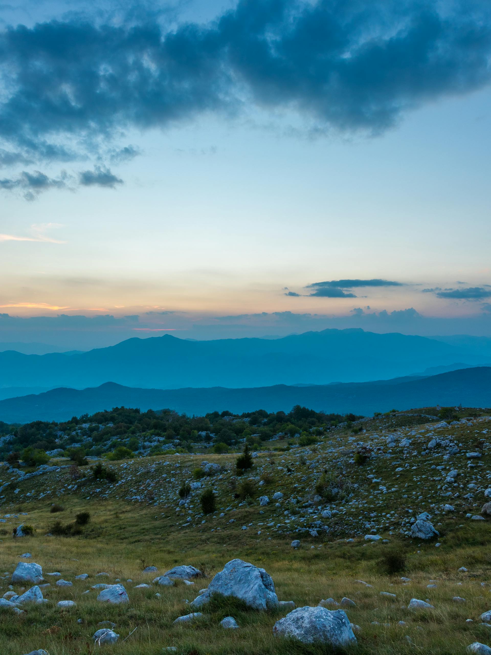 Stunning view of the Montenegrin mountains at sunset with rocky fields and a serene sky.
