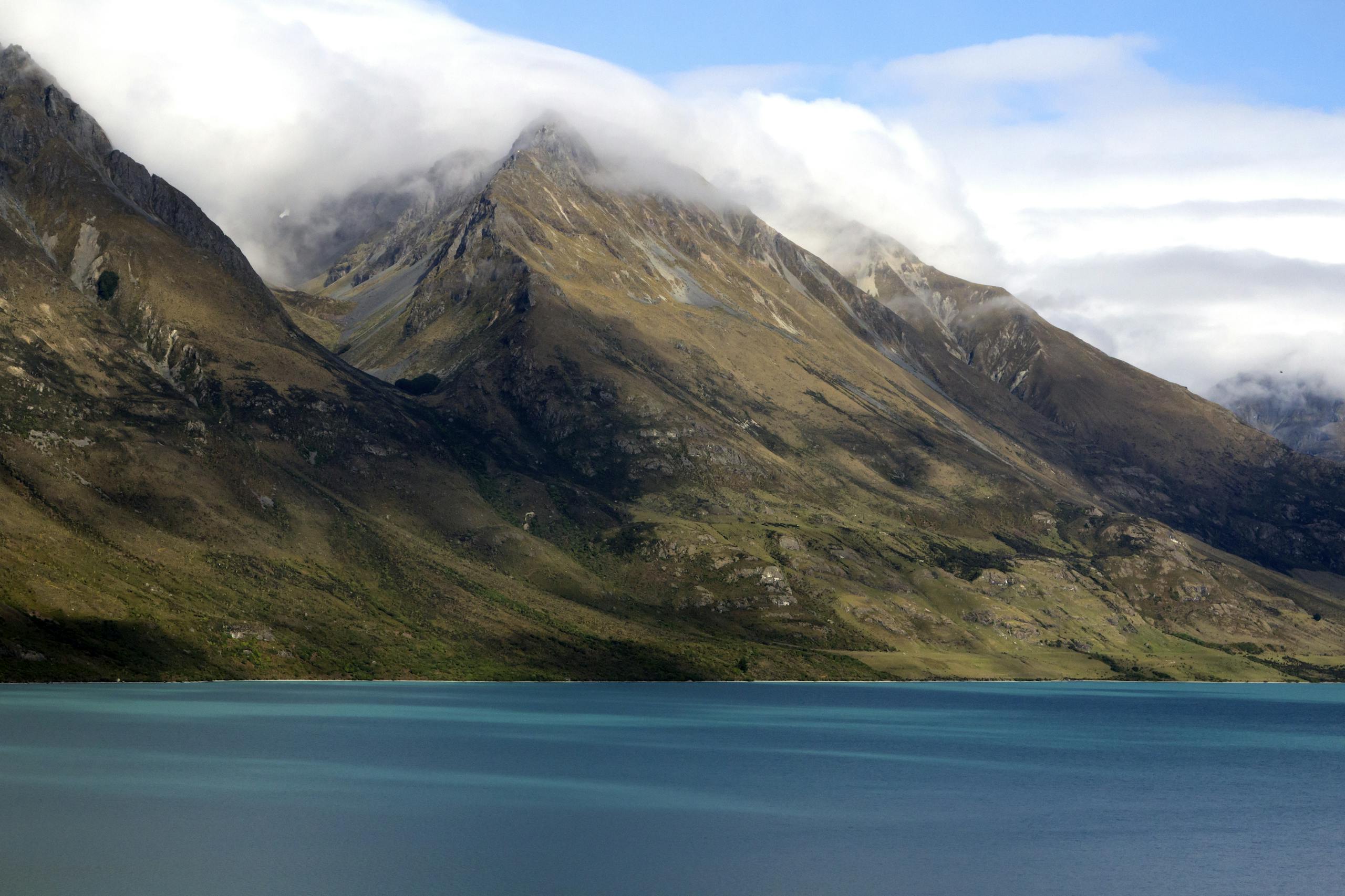 Stunning view of the Southern Alps reflecting in Lake Wakatipu's turquoise waters.