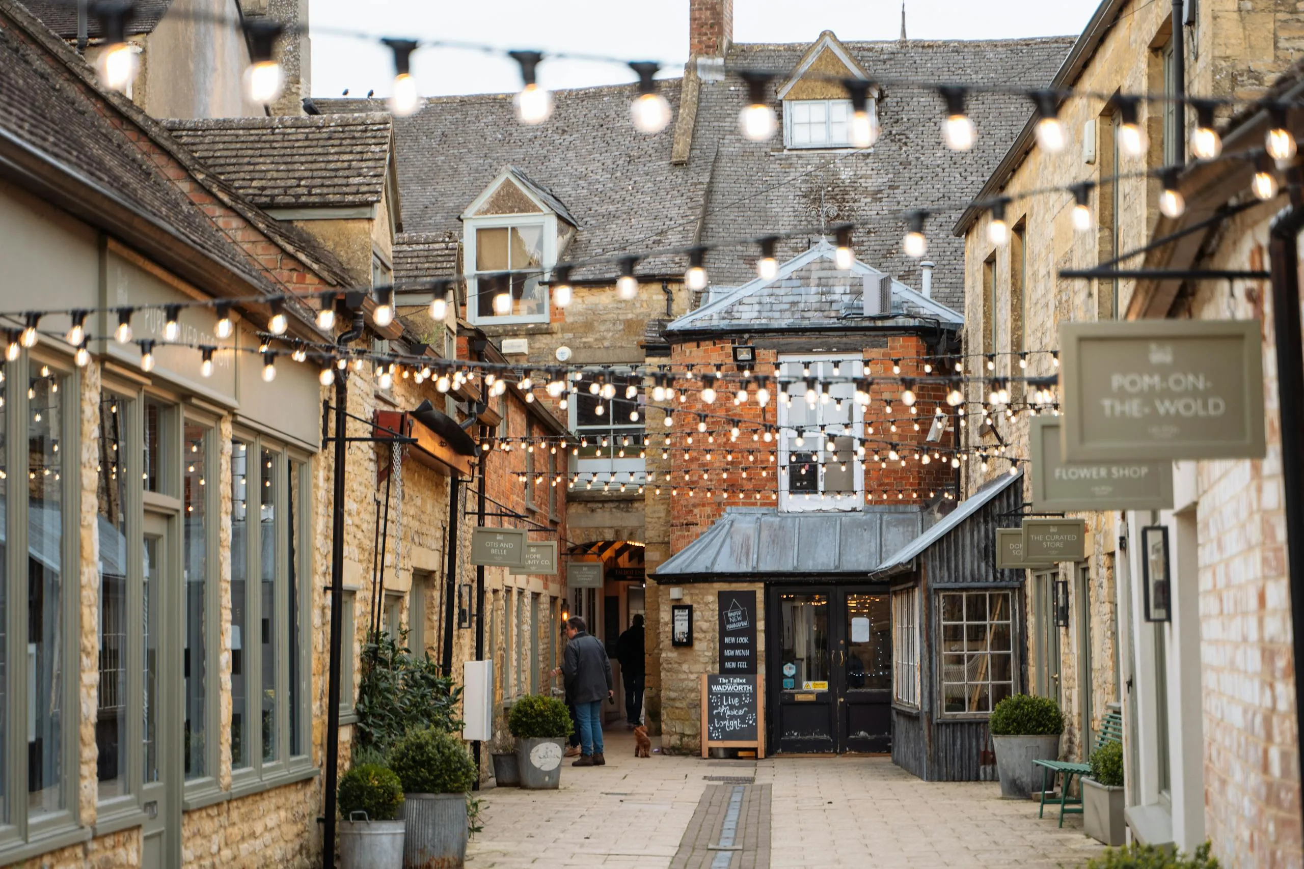 Explore the serene beauty of a traditional English village street with shops and cafes.