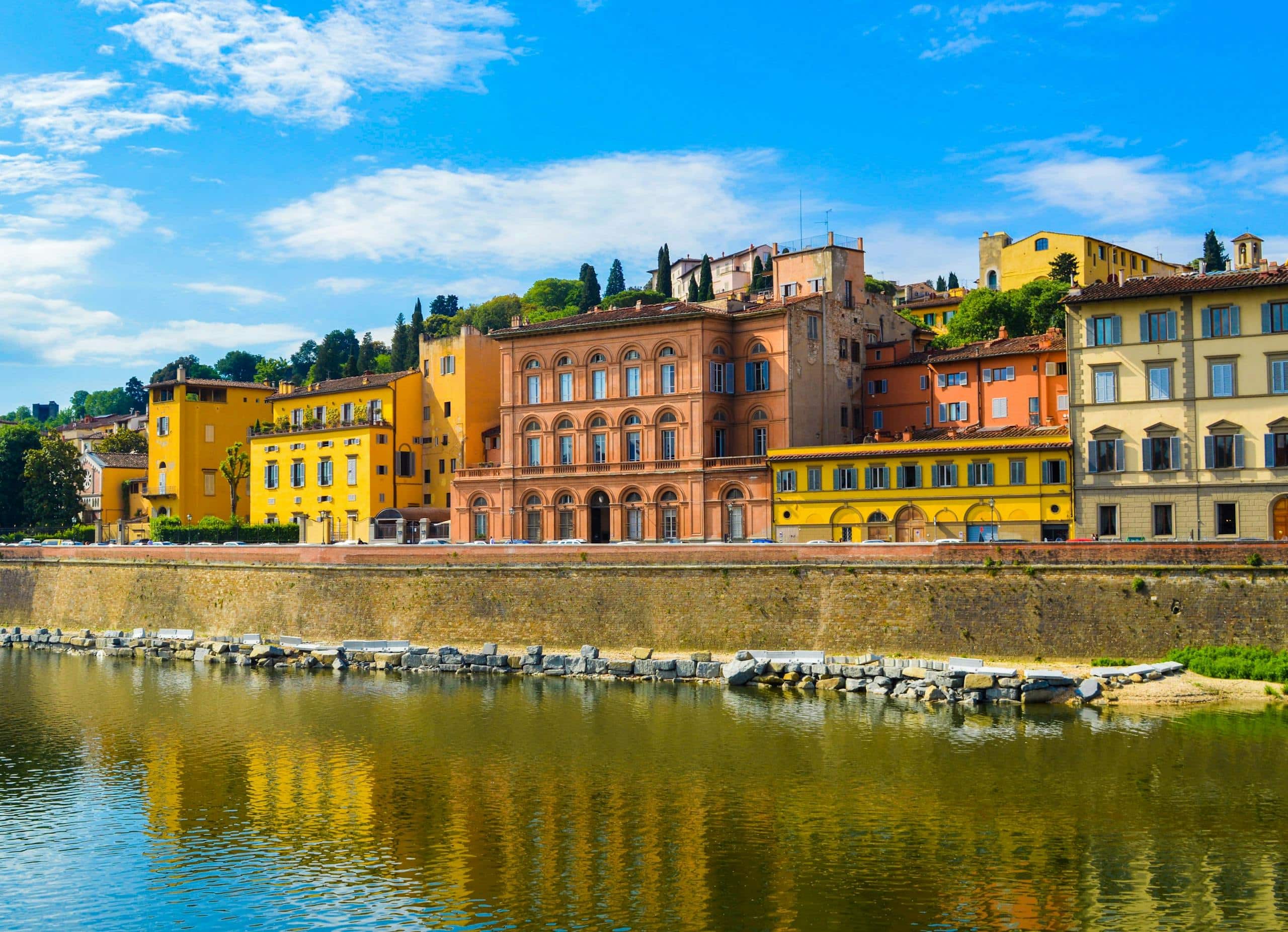 Charming view of colorful historical buildings by the Arno River in Florence, Italy.