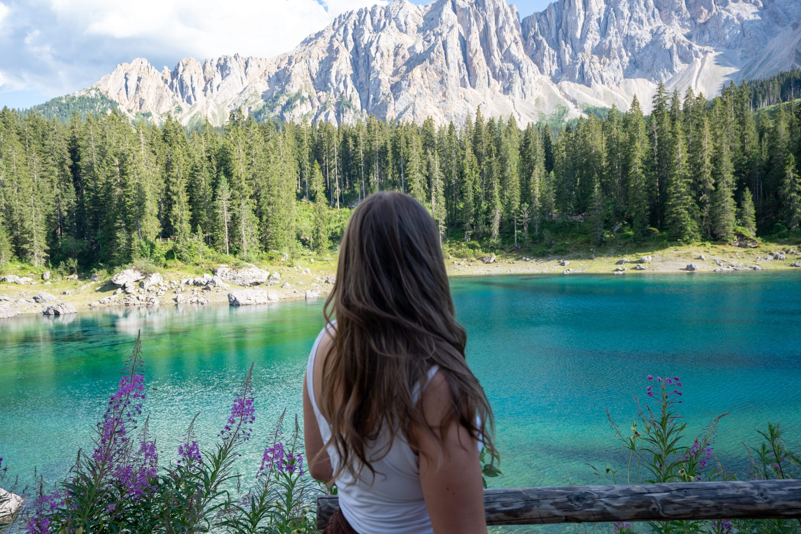 standing at Lago di Carezza's emerald water with the Latemar peaks, Dolomites, Italy