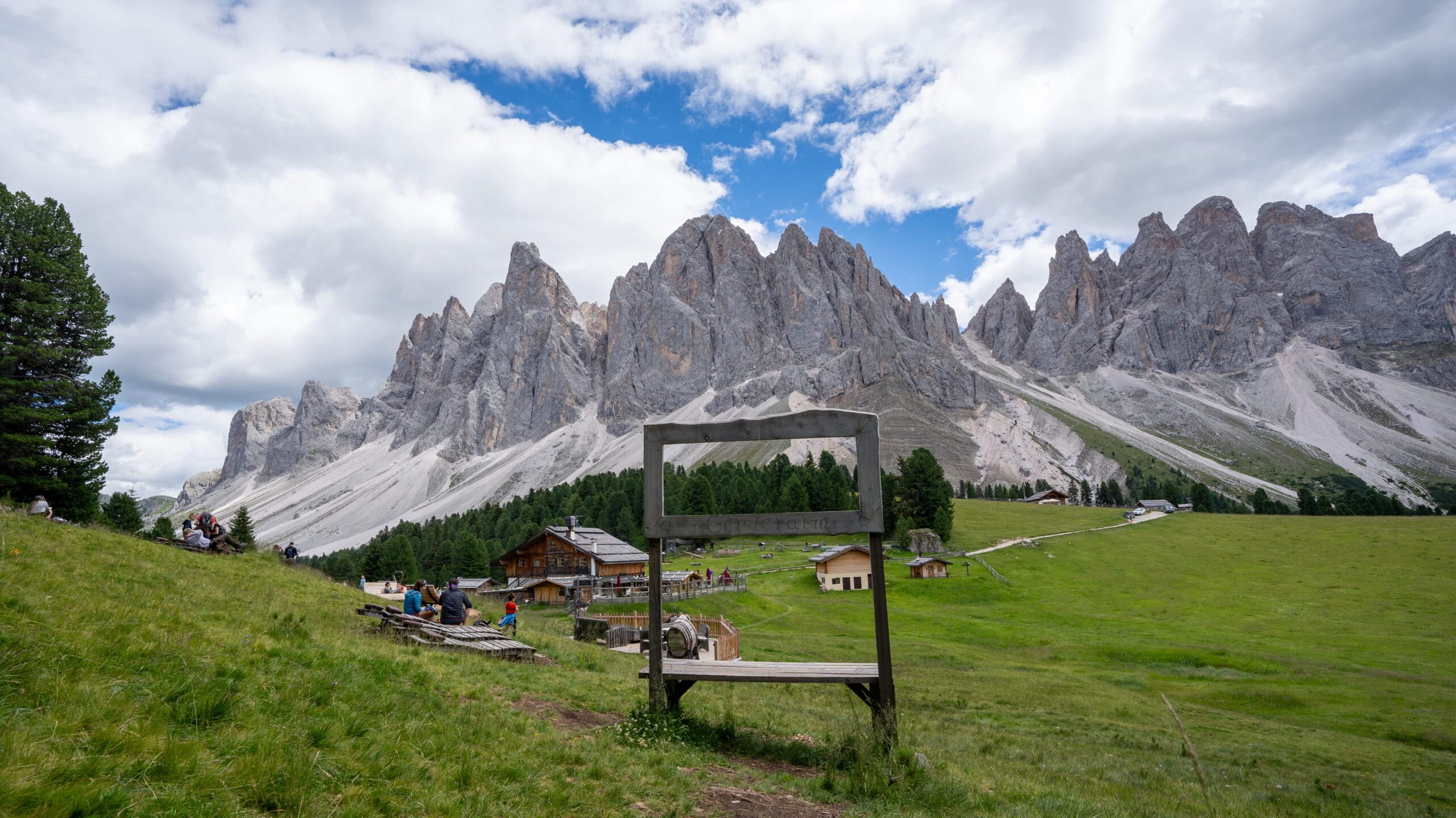 Geisler Alm sign with the Odle peaks behind it, Val di Funes, Dolomites
