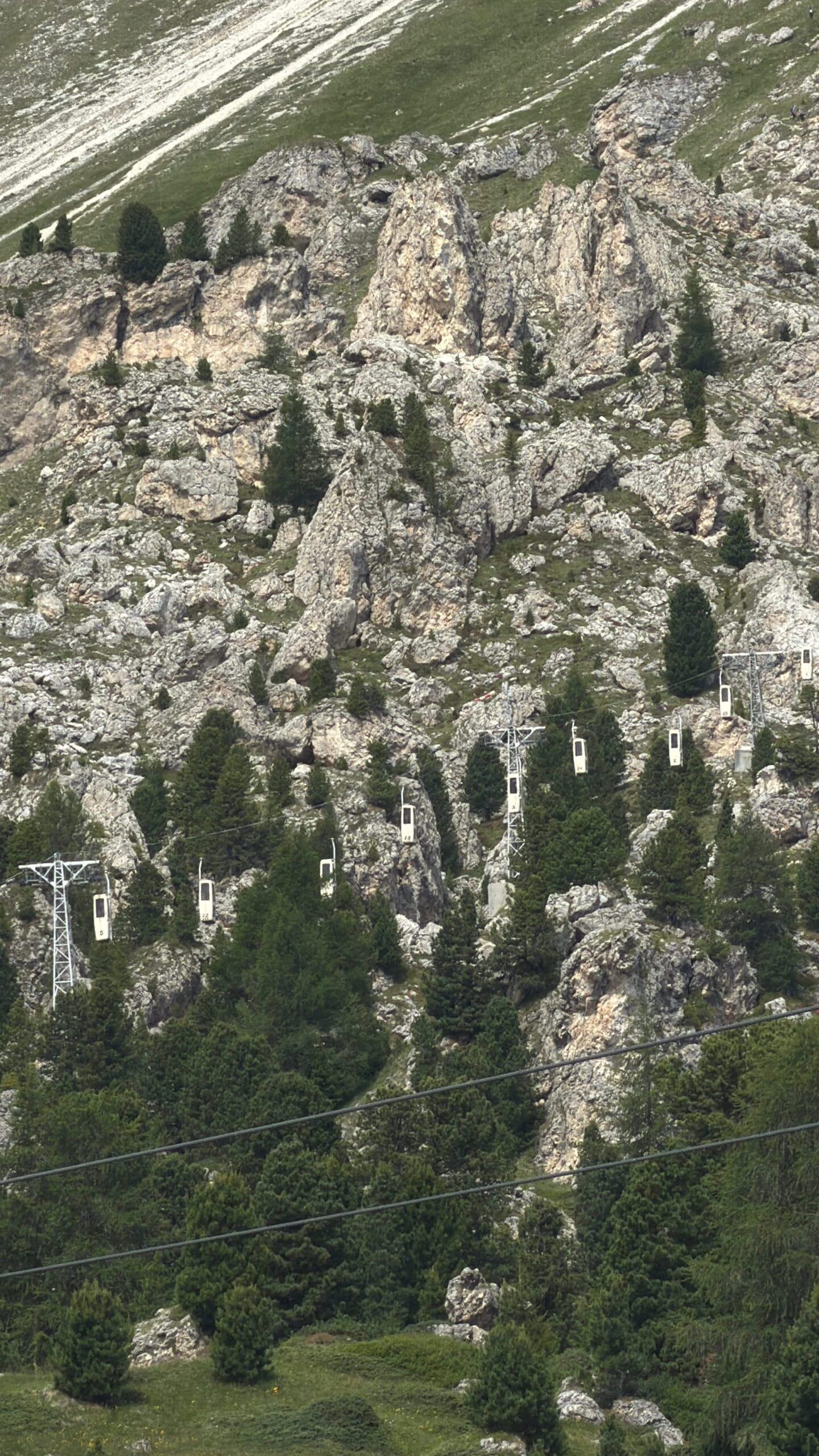Vintage cable cars crossing the rocky cleft near Sassolungo, Val Gardena, Dolomites
