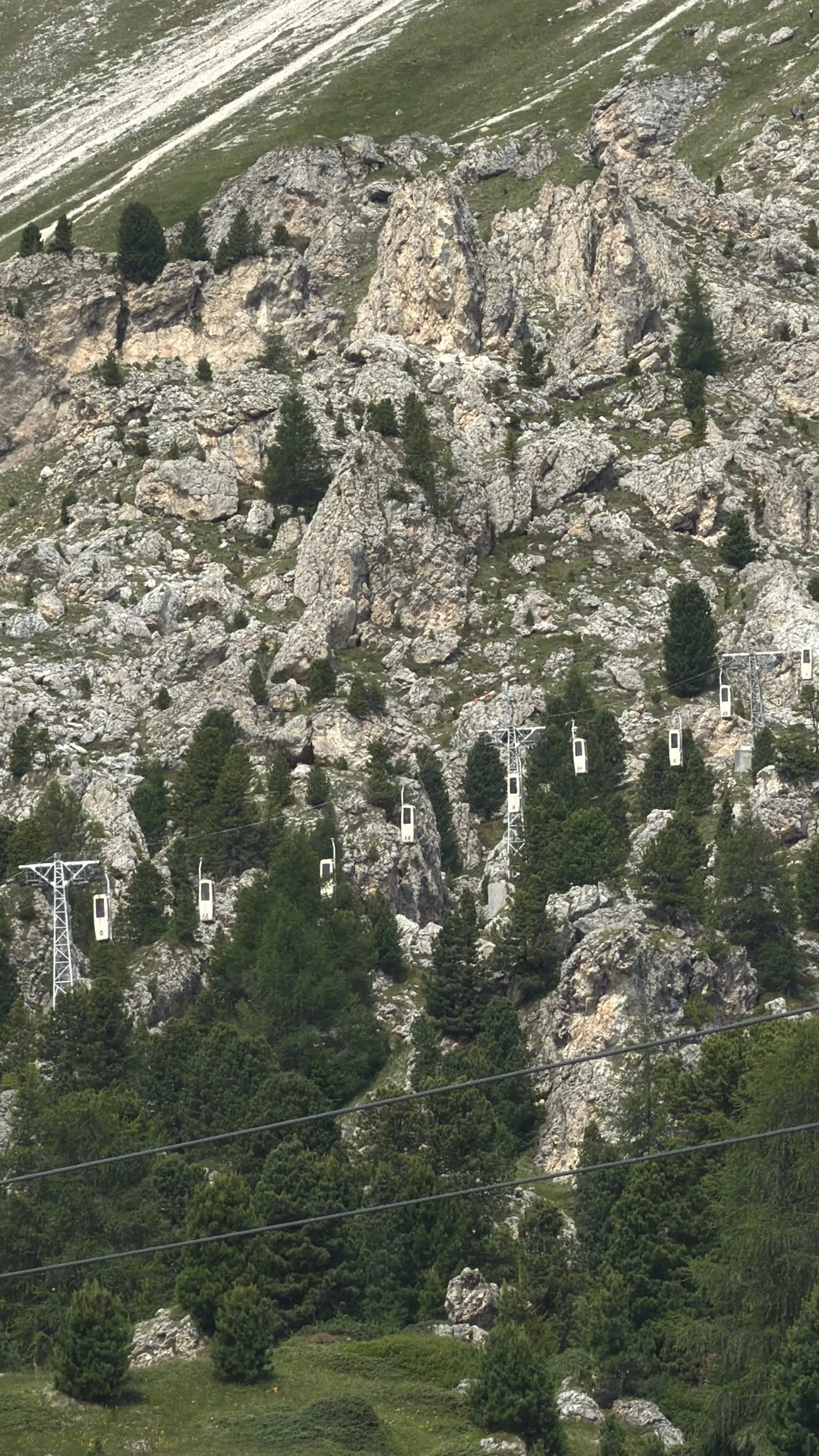 Vintage cable cars crossing the rocky cleft near Sassolungo, Val Gardena, Dolomites