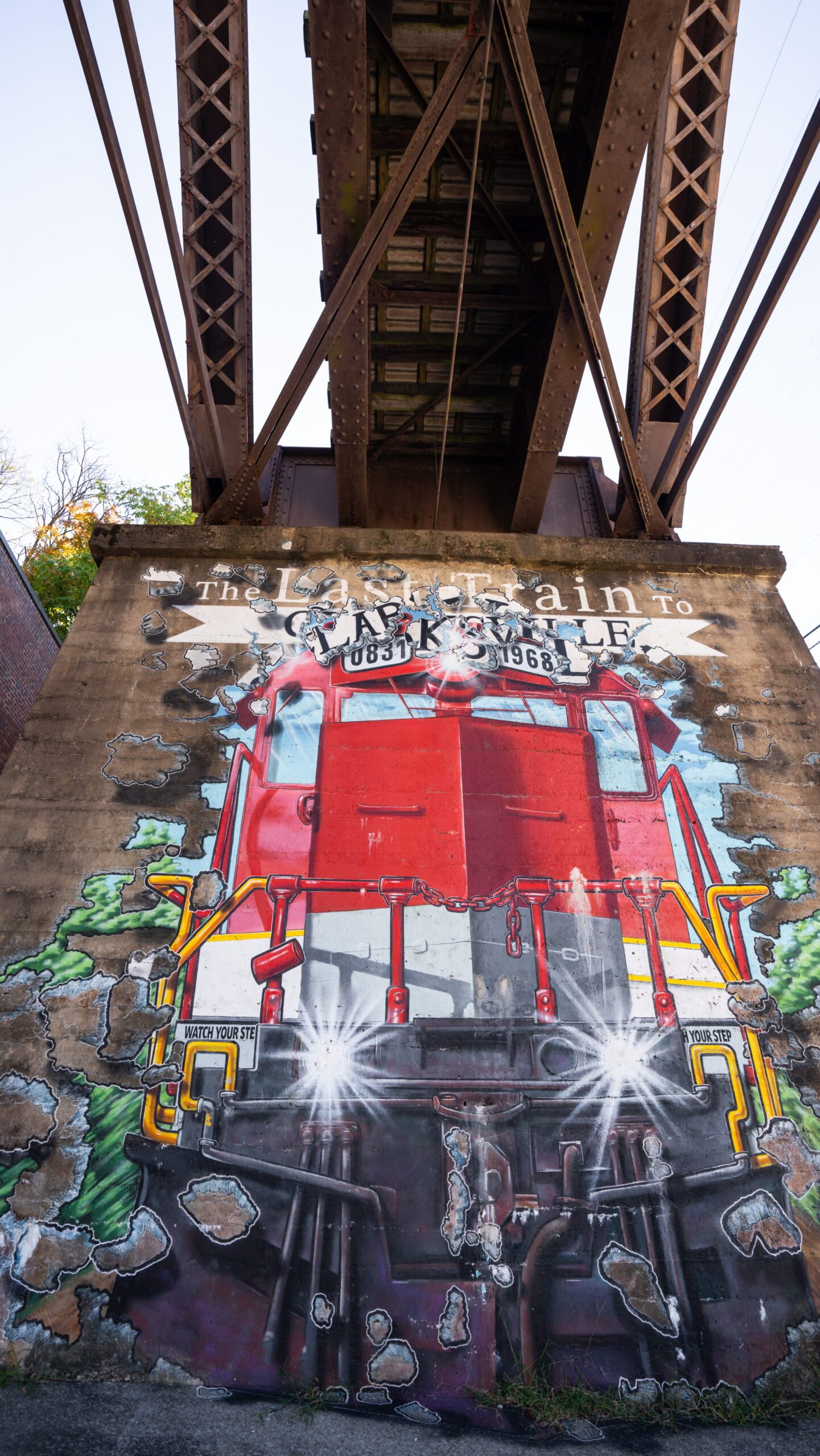 Last Train to Clarksville mural painted on a stone pillar under the railroad bridge in downtown Clarksville, TN