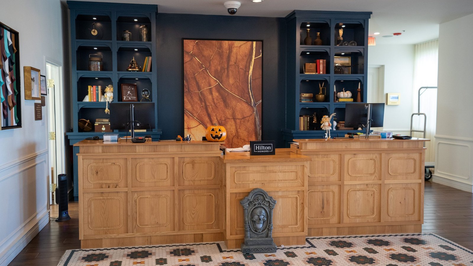 Front desk in the lobby of the DoubleTree by Hilton Clarksville Downtown with navy bookshelves and Halloween decor