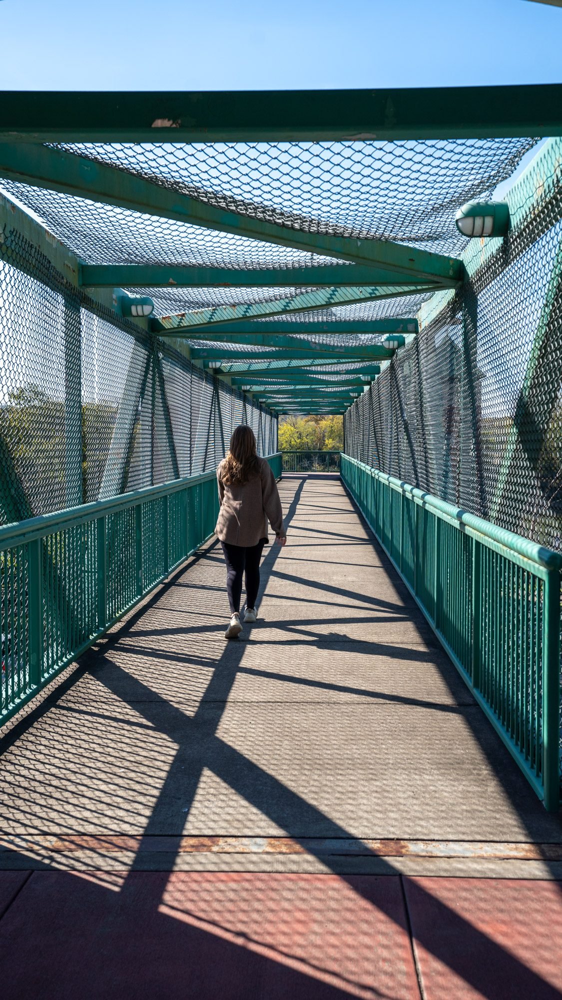 Walking across the green pedestrian bridge at the Cumberland Riverwalk in Clarksville, Tennessee
